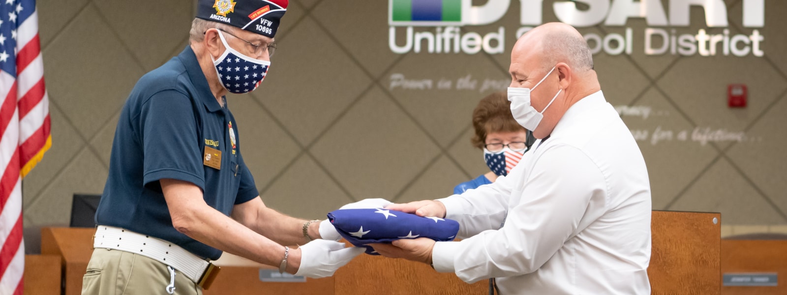 Dennis Grau from the VFW presents a flag to Jim Dean.