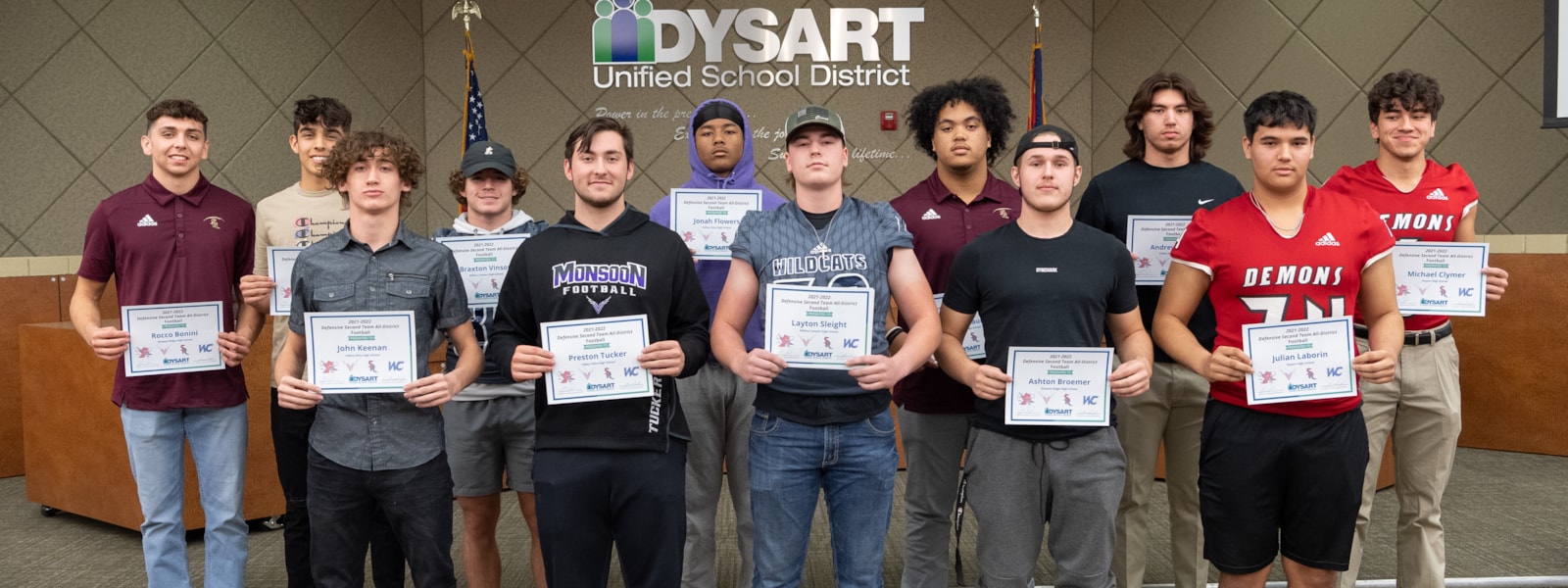Football players pose with their certificates.