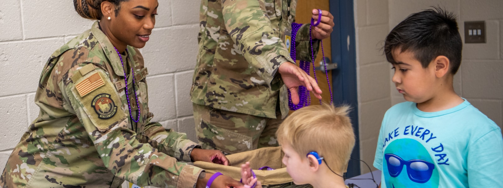 Military handing out purple beads  to children