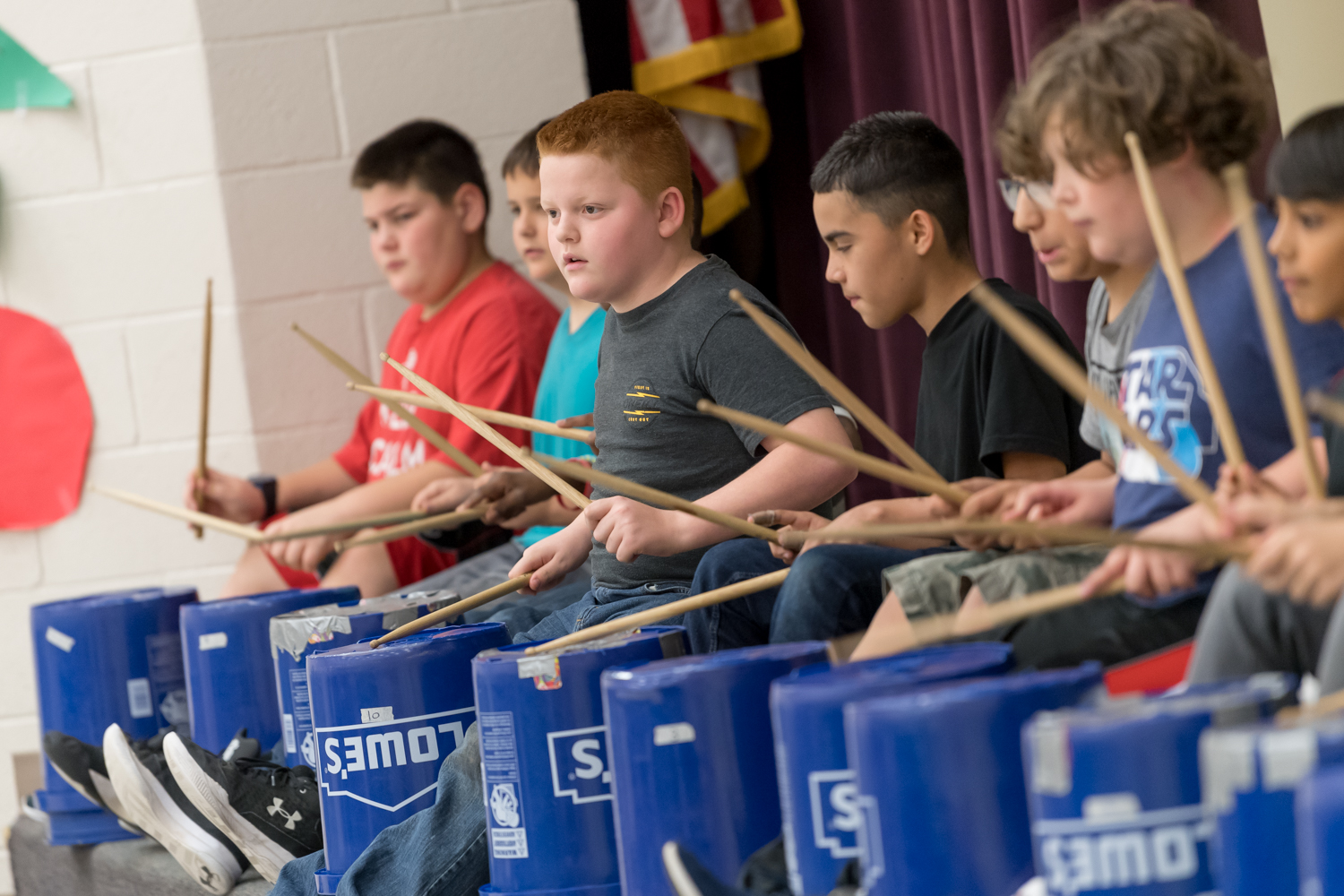Students playing bucket drums. 
