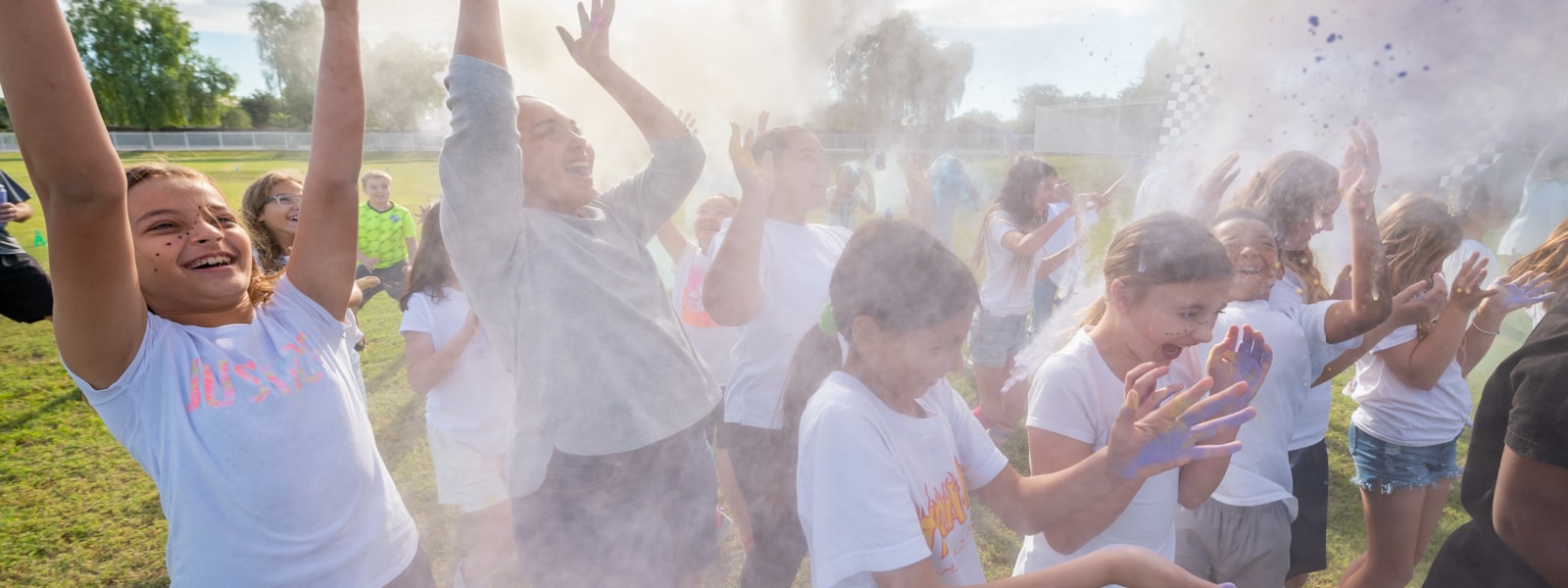 Students throwing up colored chalk in the air during the color run