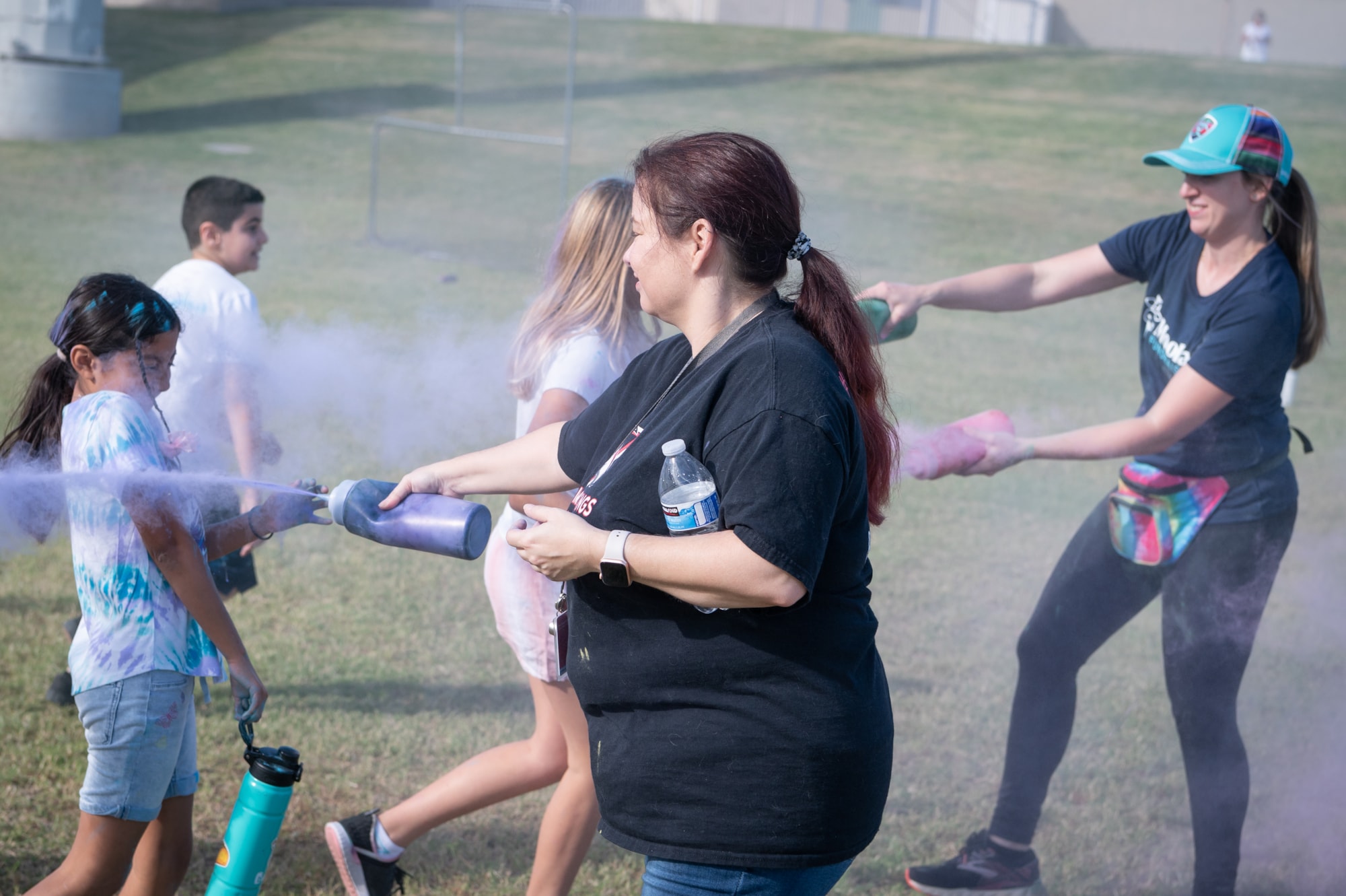 teacher spraying students with colored powder