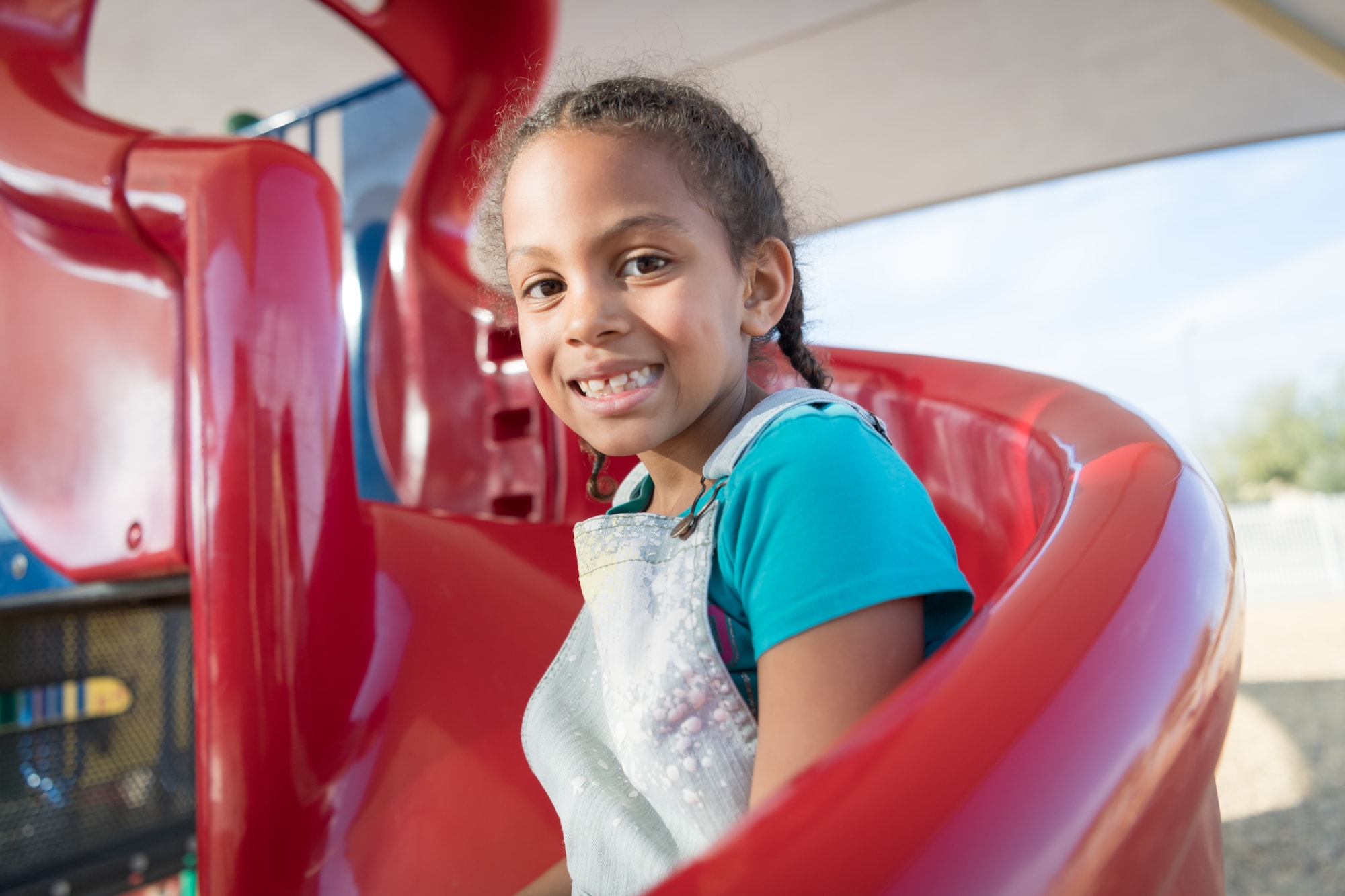 Student smiling on playground slide