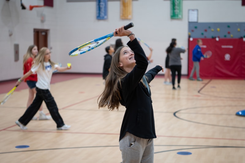 students in PE Classroom playing badminton