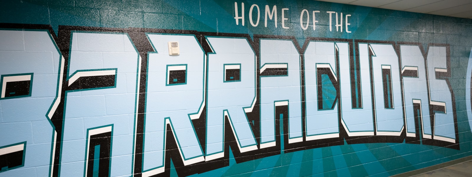 wall wrap on school wall saying home of the barracudas