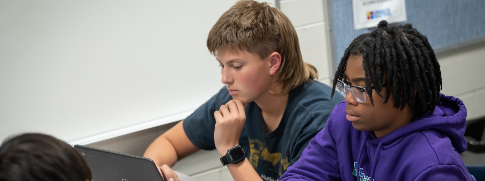 two students studying on chrome books