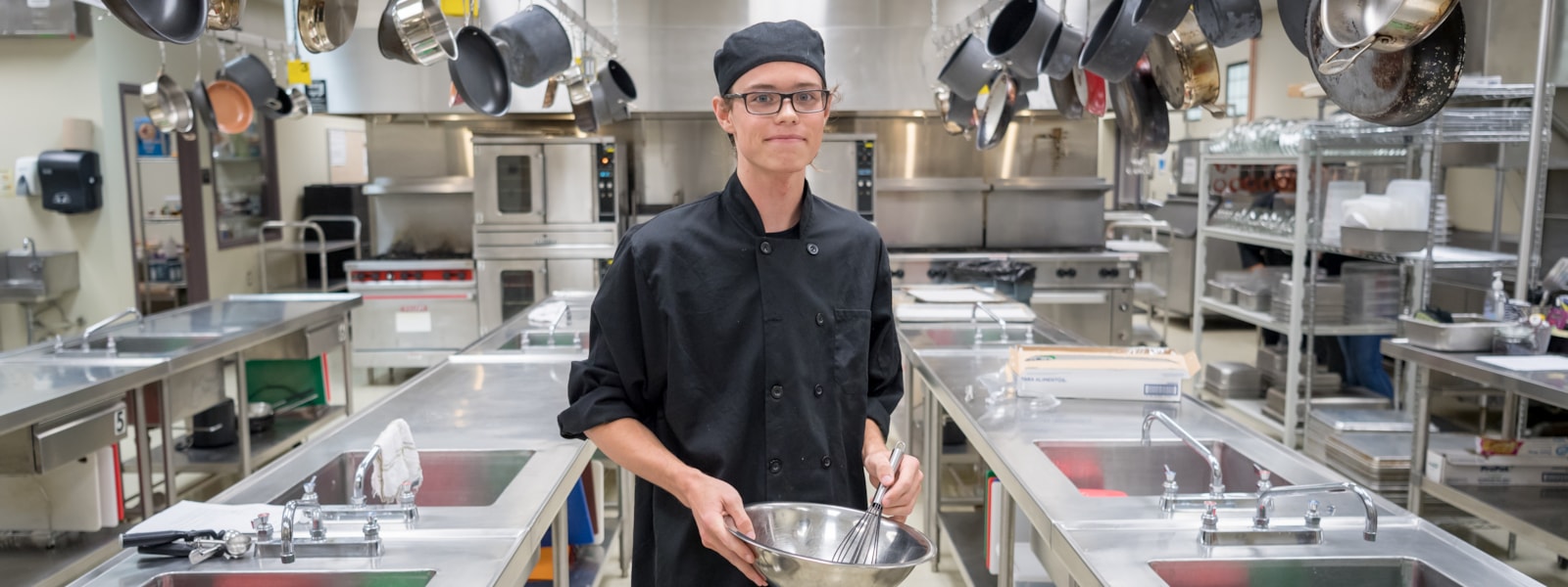 Student holding a mixing bowl and wisk