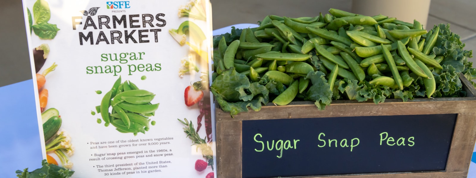 fresh snap peas in wooden crate