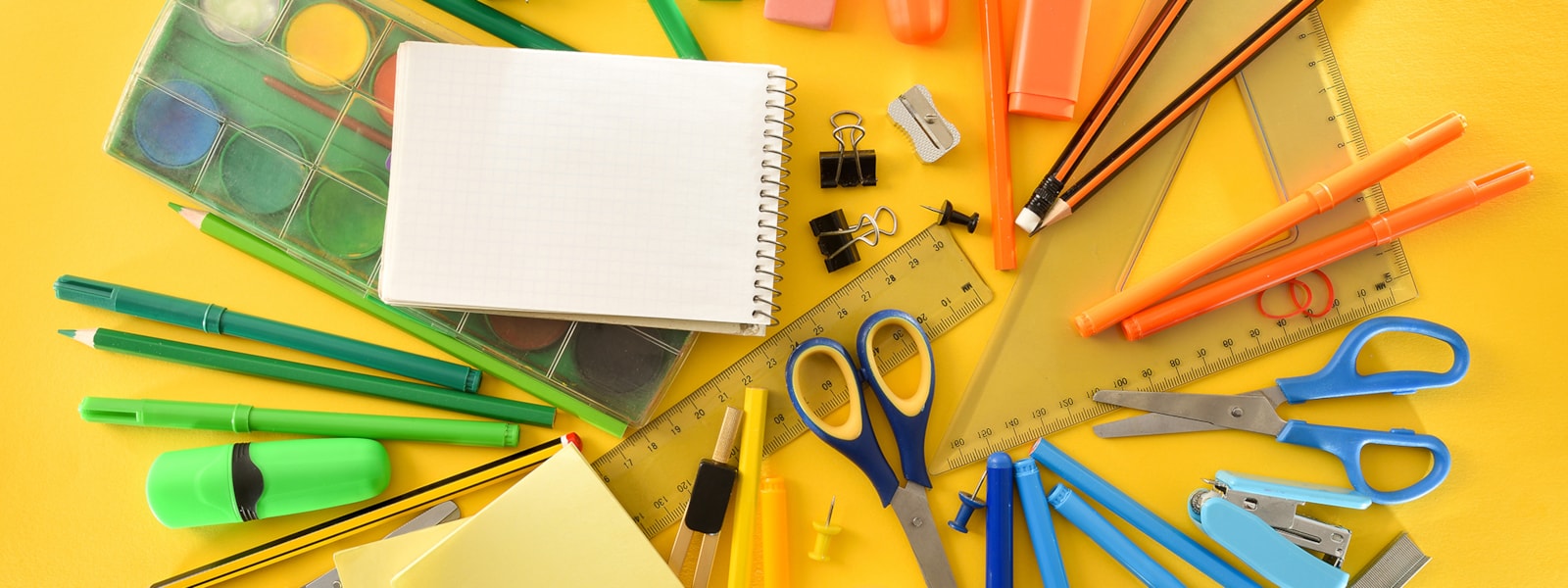 school supplies laid out on a yellow background