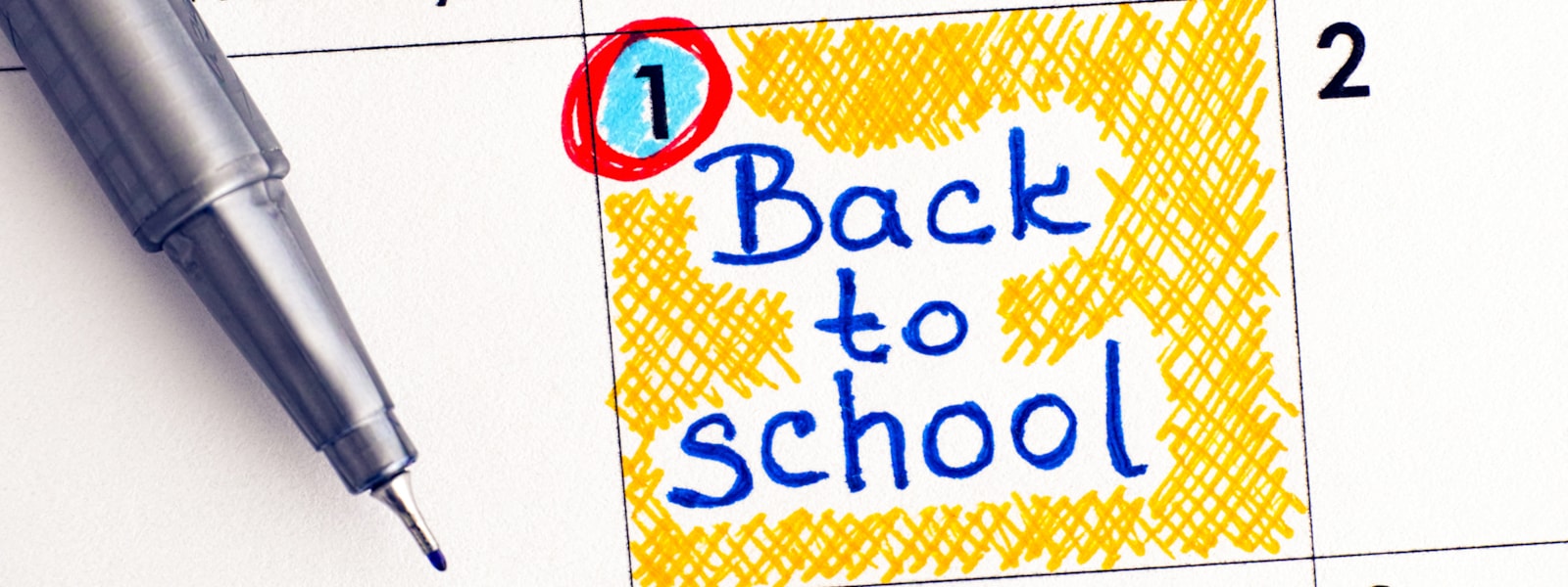 date circled on a calendar and 'back to school' written on it, pen sitting on calendar
