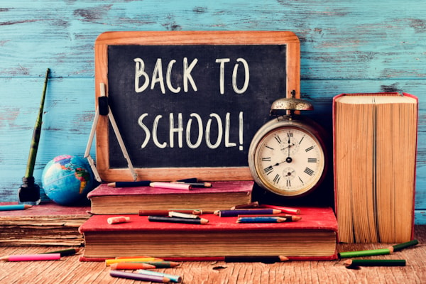 Back to School sign with clock, book, globe and school supplies