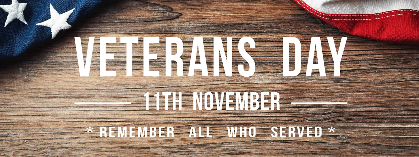 wood background behind a US Flag and Veterans Day 11th November *Remember All Who Served*