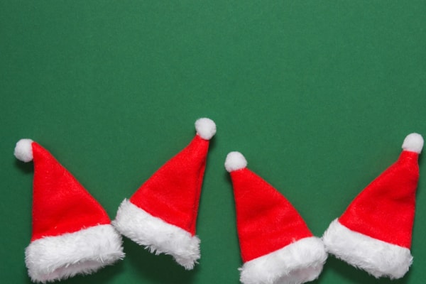 four santa hats with a green background 