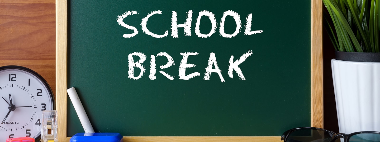 school break written on chalkboard with school supplies