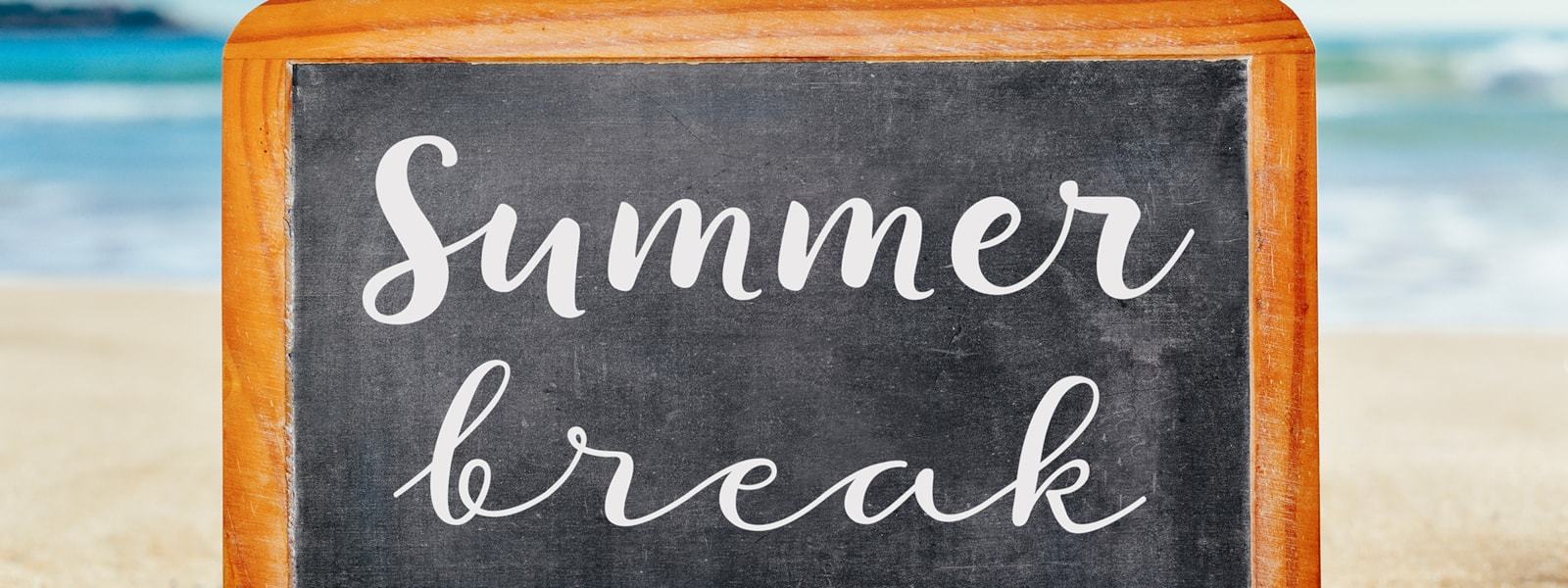 beach scene with a chalkboard that says summer break