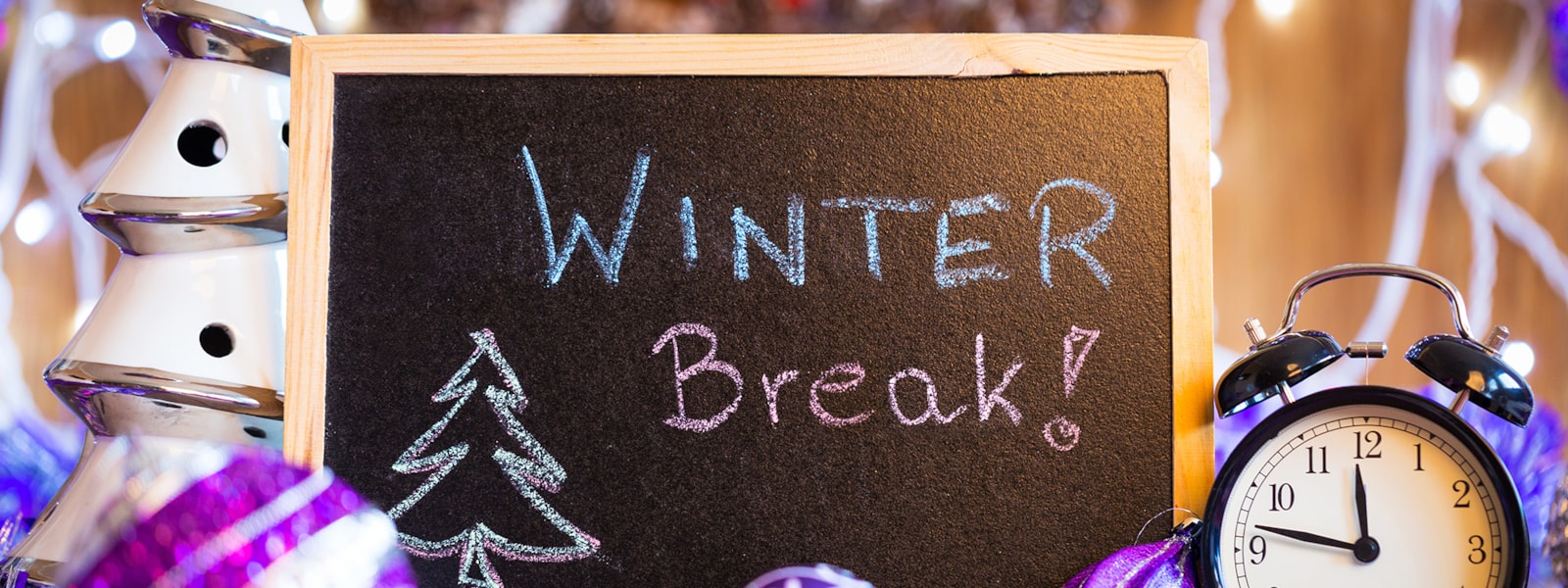 Winter Break written on a chalkboard with a clock and ornaments