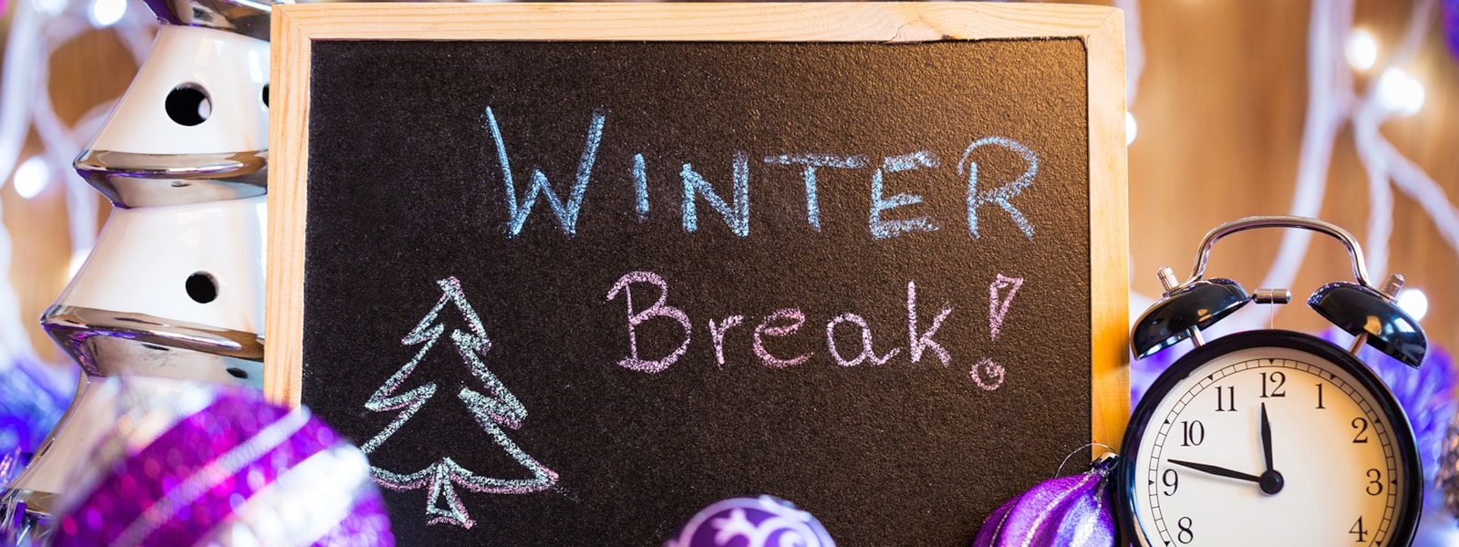 Winter Break written on a chalkboard with a clock and ornaments