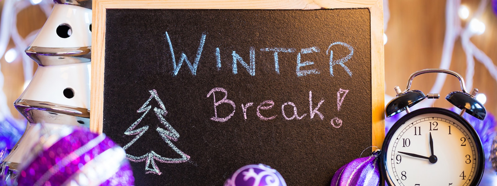 winter break! on chalkboard next to purple ornaments and an alarm clock