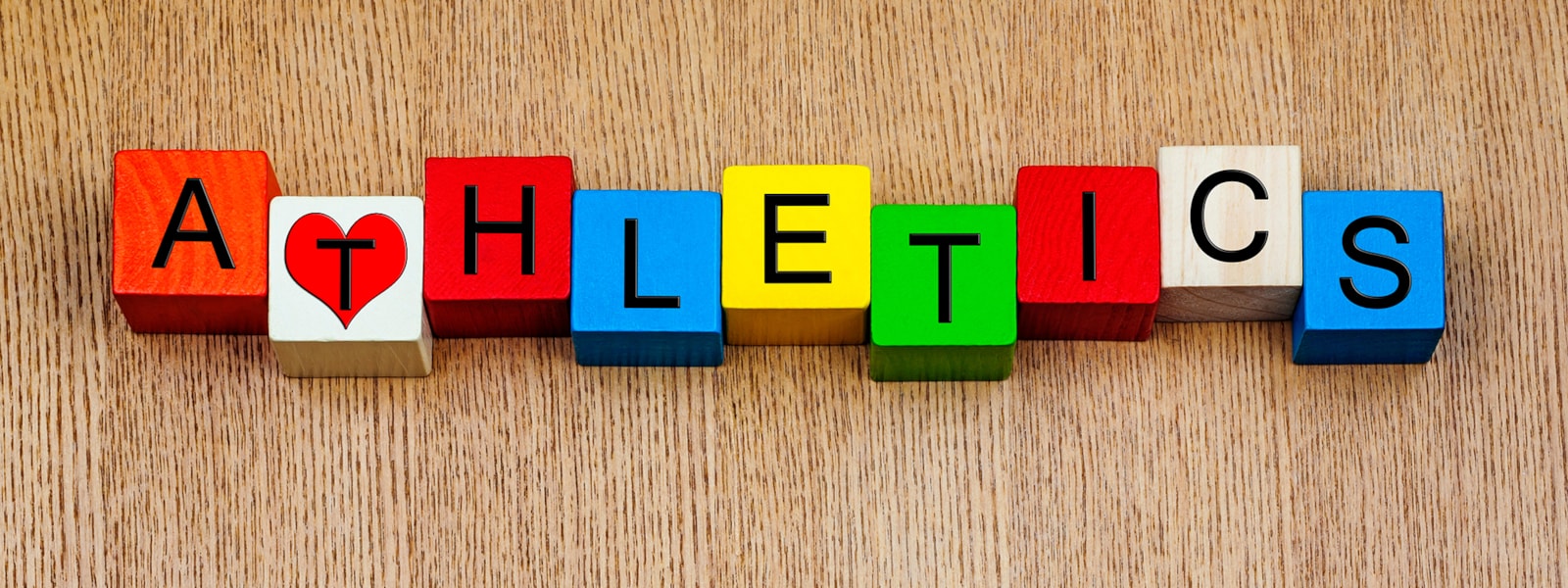 wooden blocks spelling 'athletics' on a wooden background