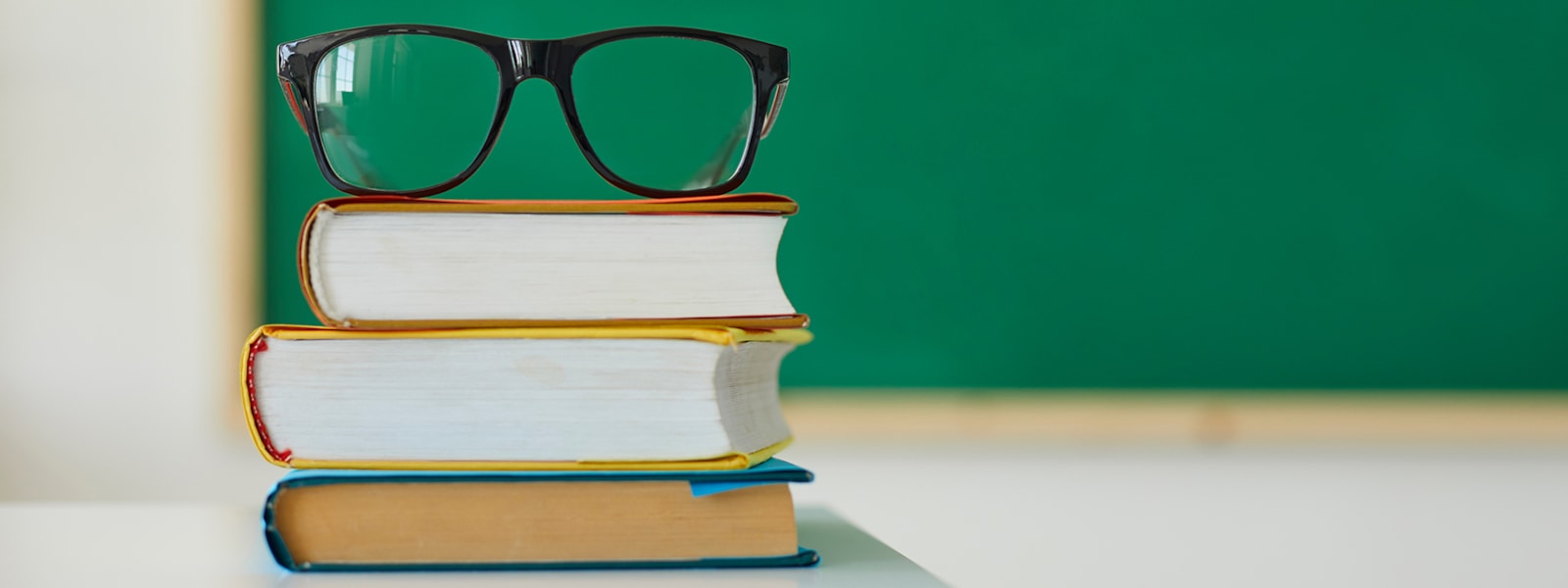 pair of glasses on books
