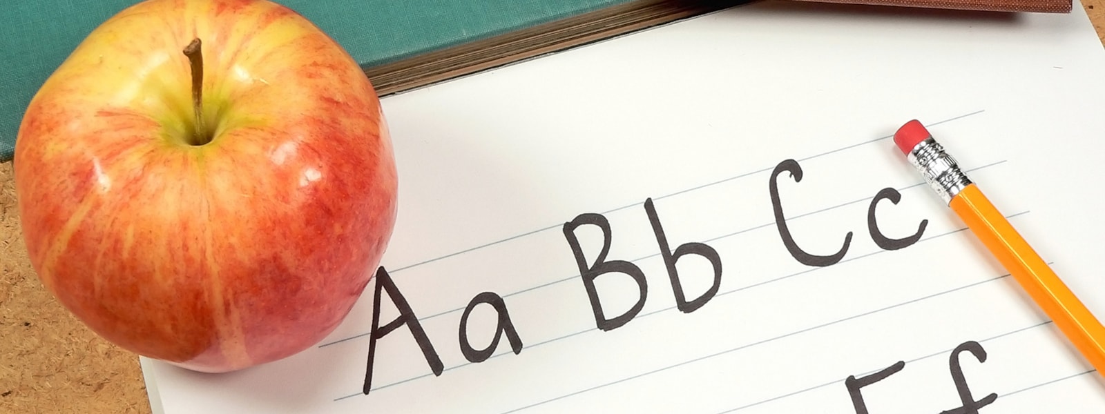 notebook with ABCs, pencil and apple