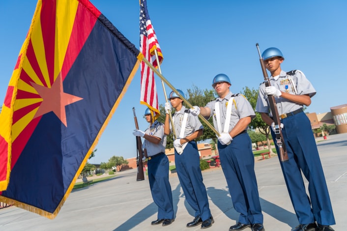JROTC students holding american flag and arizona state flag in uniform