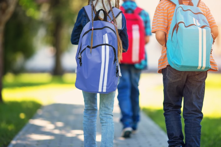 students walking to school on a sidewalk outside