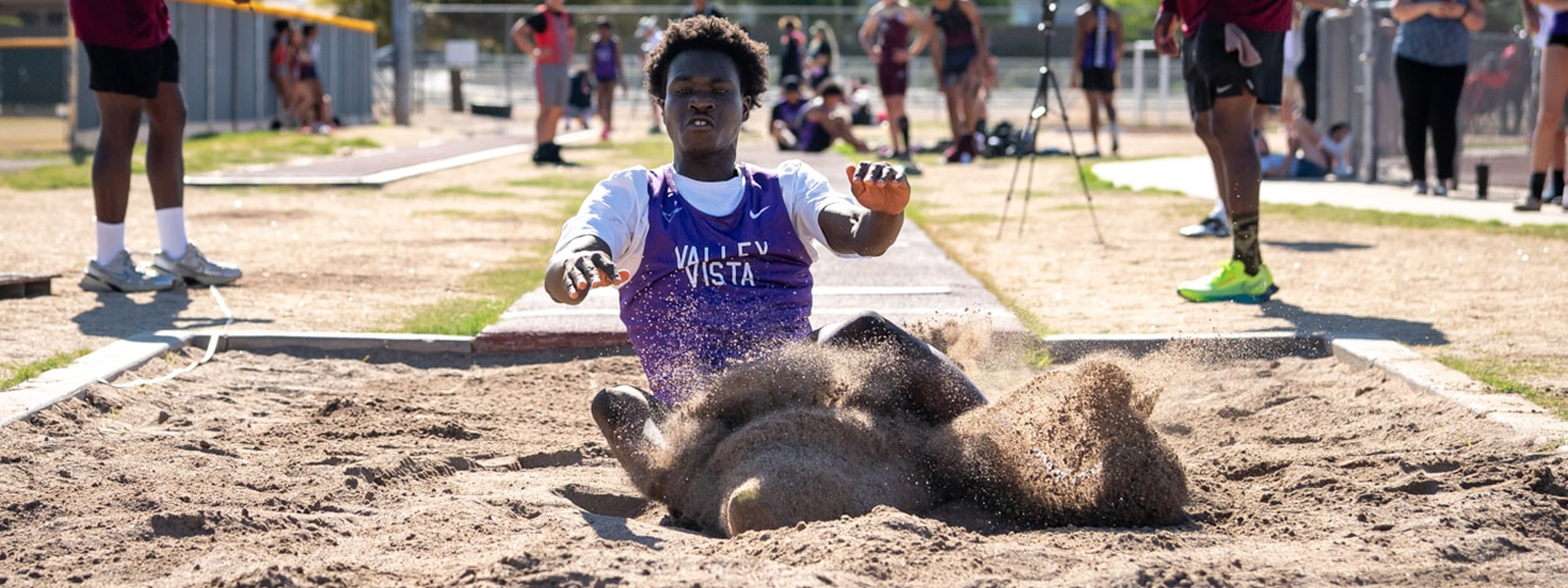 student athlete competing in the long-jump at district track and field meet.