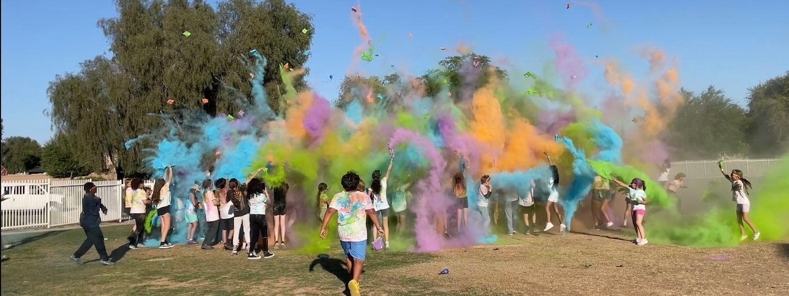 kids throwing colored chalk in the air