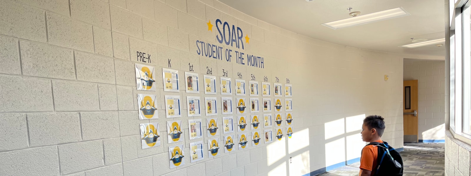 Student looking at Student of the Month Wall