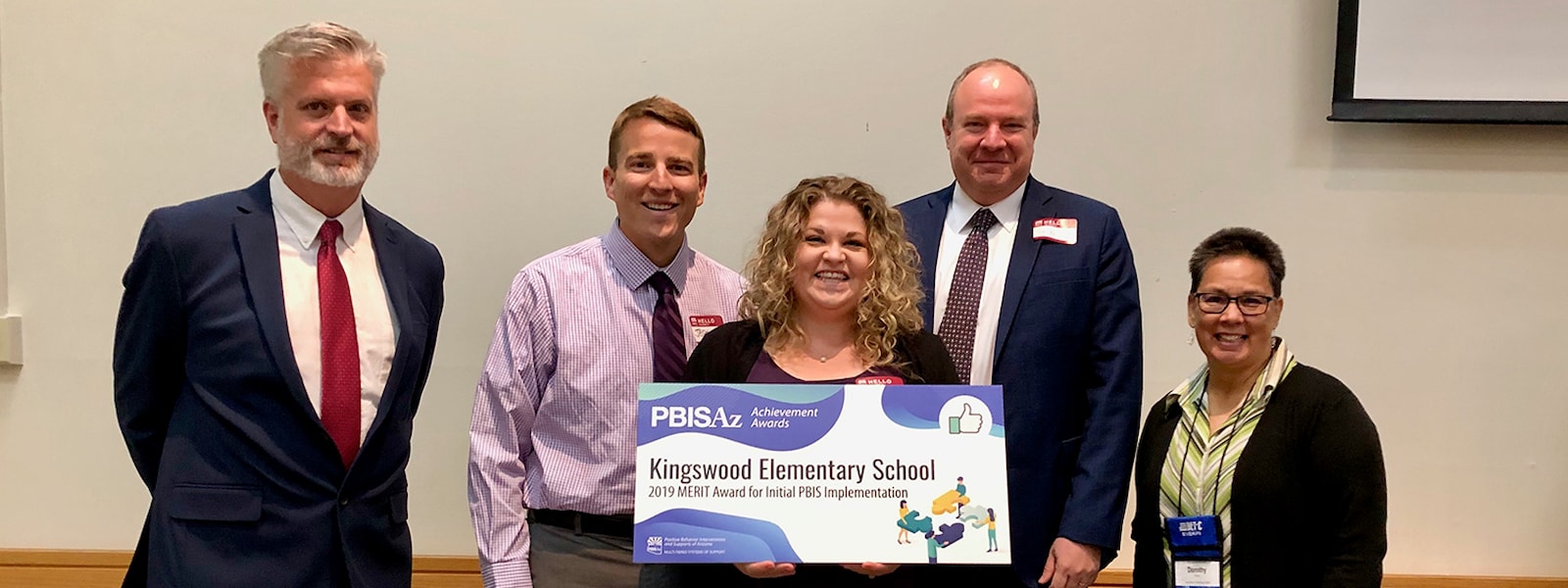 Dr. Kellis and Kingswood principal and assistant principal pose with a Merit Achievement Award from the Positive Behavior Intervention and Supports (PBIS).
