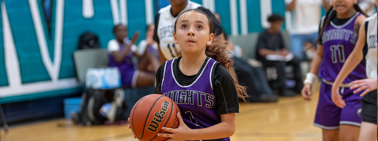 Girls basketball player holding the ball getting ready to make a shot