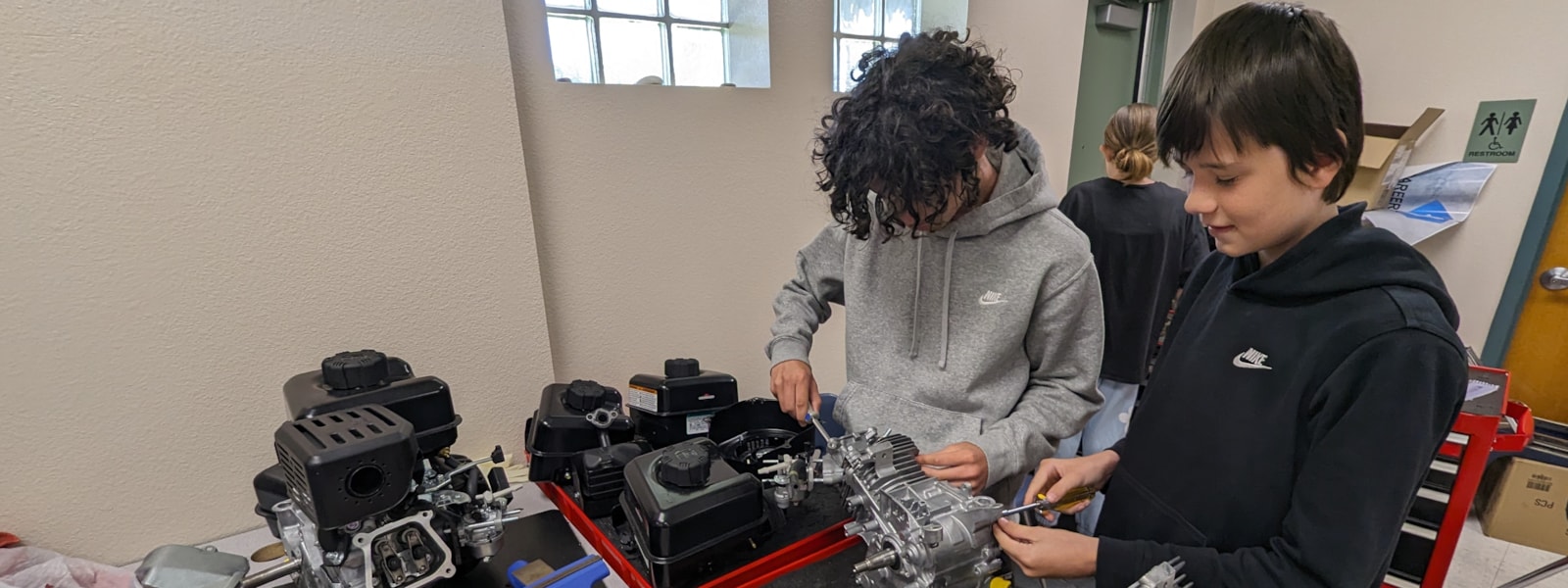 Two students working on a four stroke engine