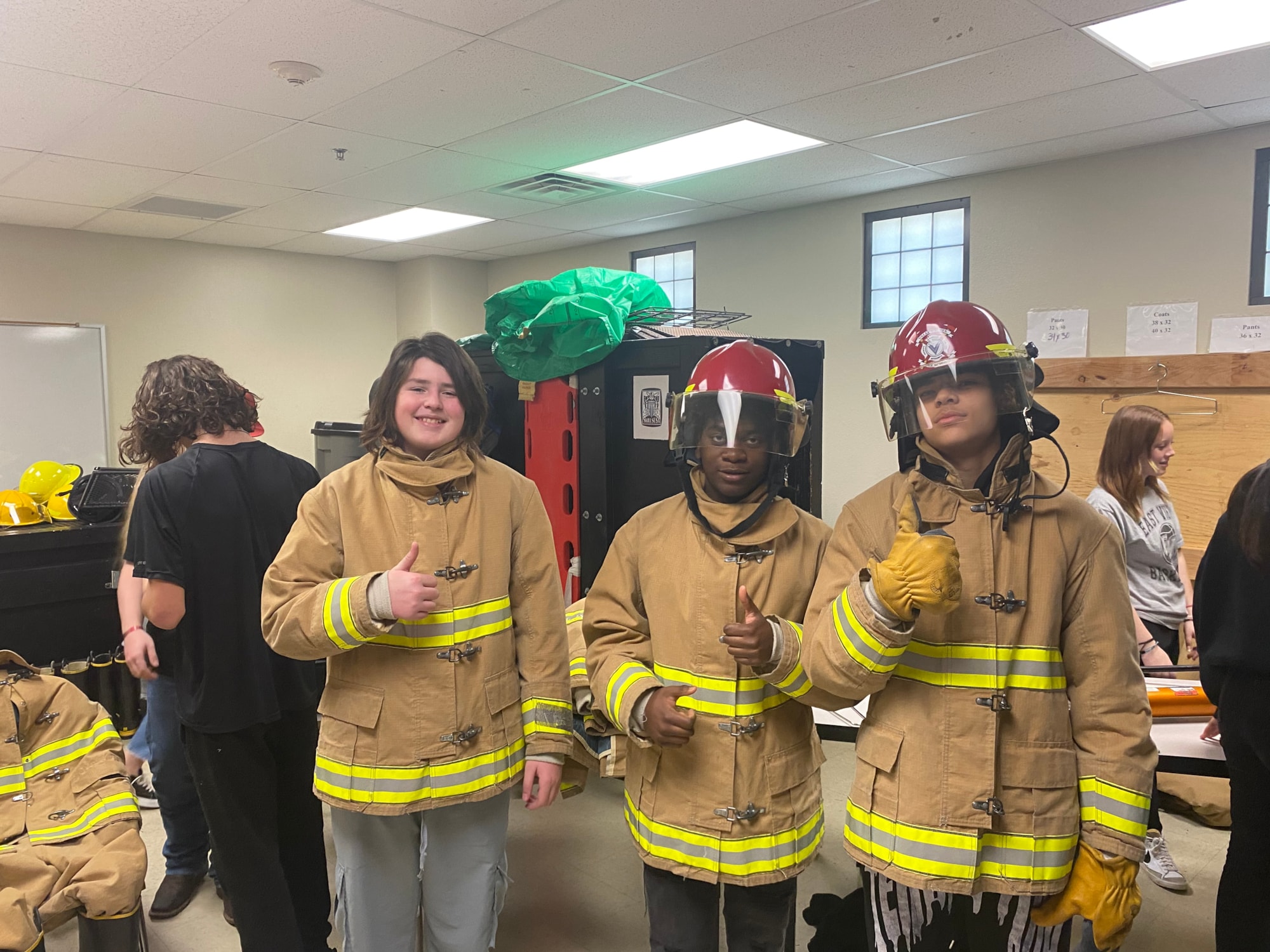 3 students pose with fire gear on