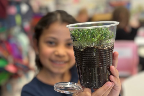 student holding alfalfa sprouts