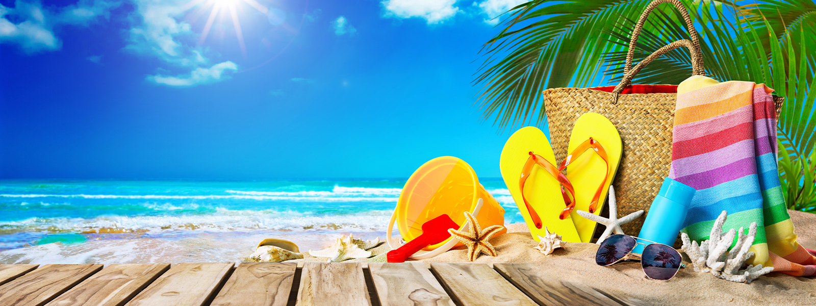 Beach scene with beach bag, flip flops, towel, and bucket to the right