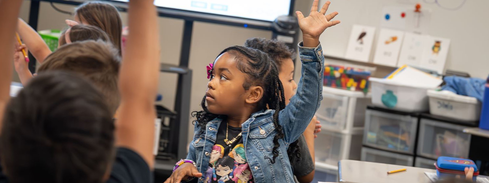 Students raising their hands in class
