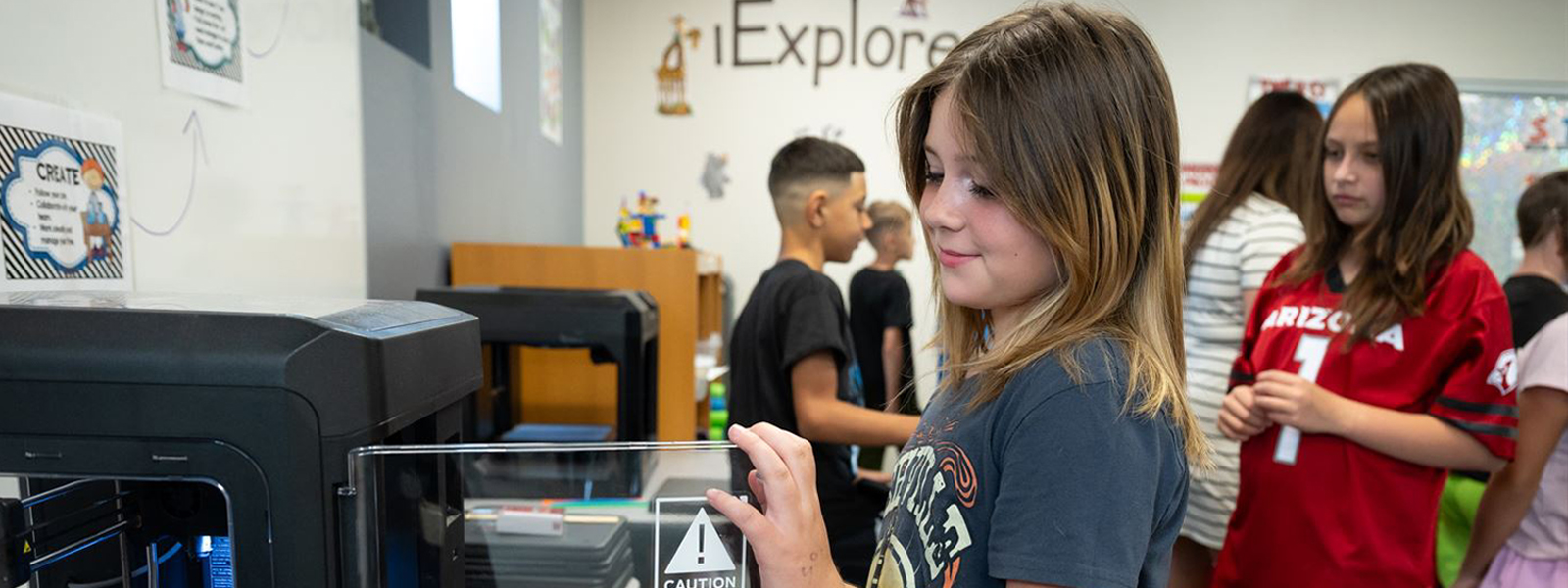 student working at a 3-D printer in iExplore class