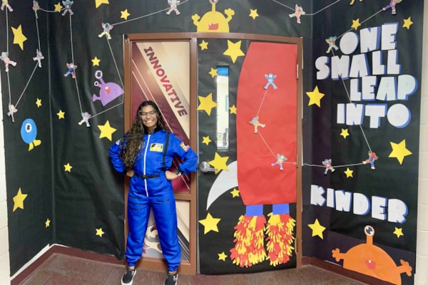 girl in space girl costume standing in front of walls decorated in space stuff