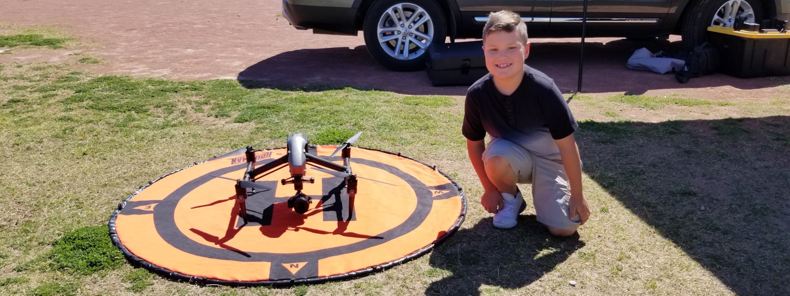 student kneeling next to a drone