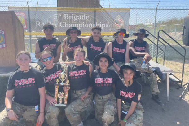 Students celebrating a raider competition with a trophy