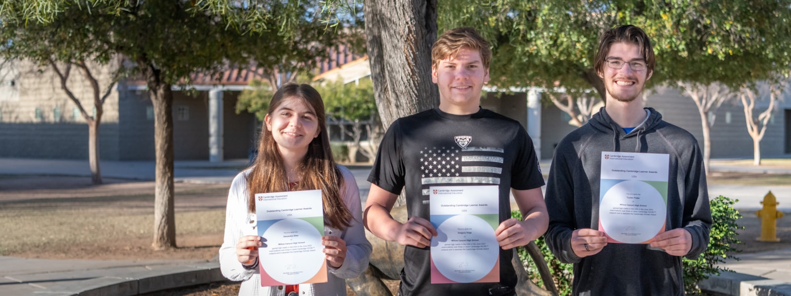 Three students holding their awards