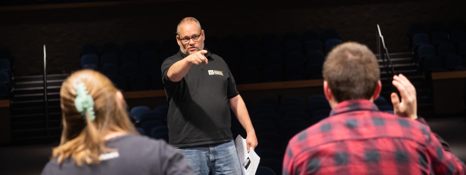 Steve Wallgren, Willow Canyon High School Theatre Teacher, speaks with students in the performing arts center.