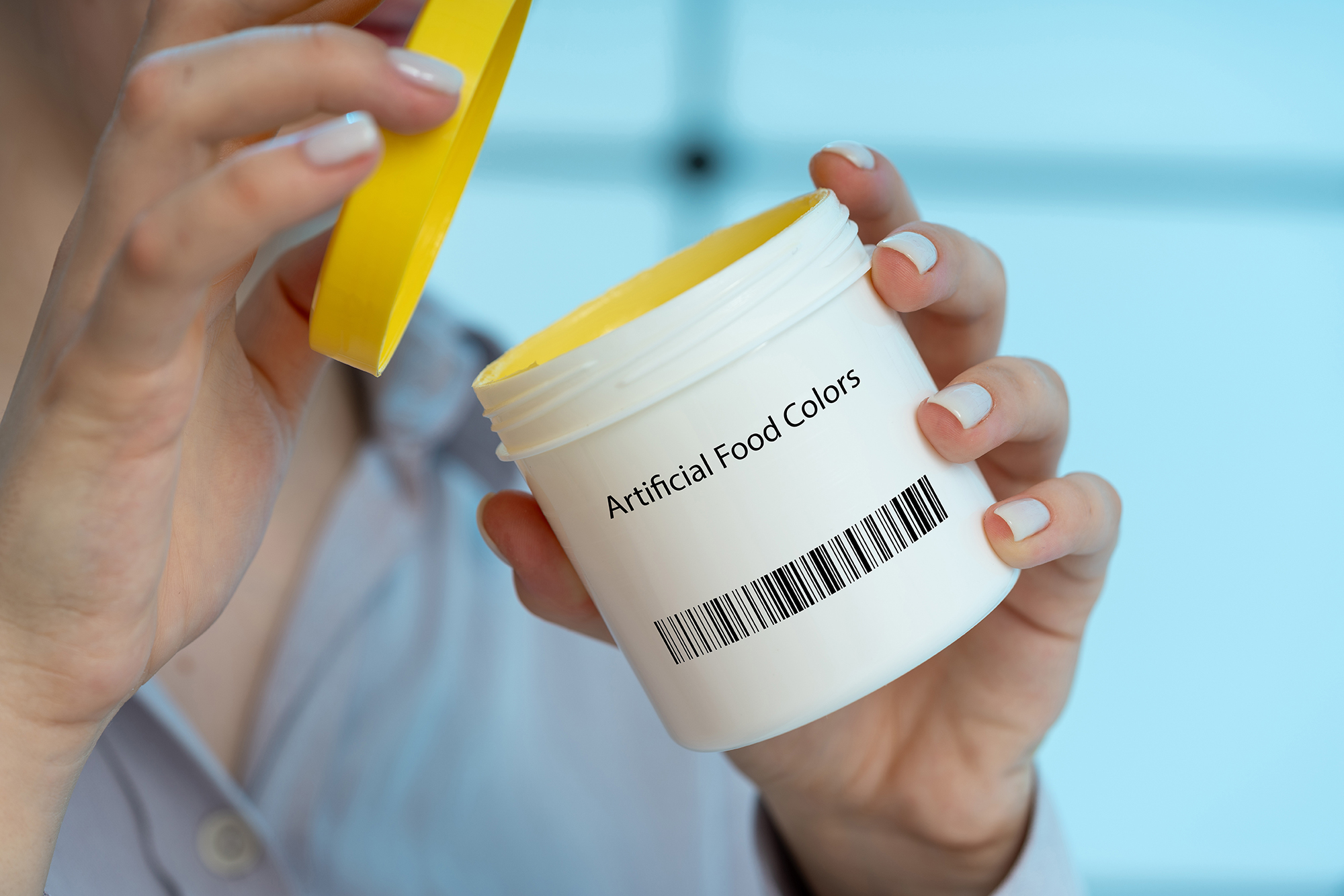 Person opening containter that says "artifical food colors"