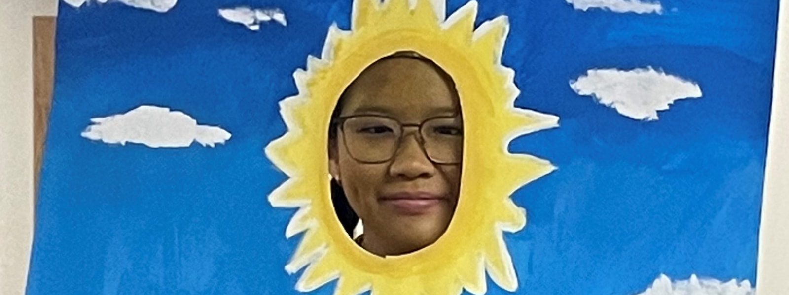 Student wearing a picture with a sun and clouds