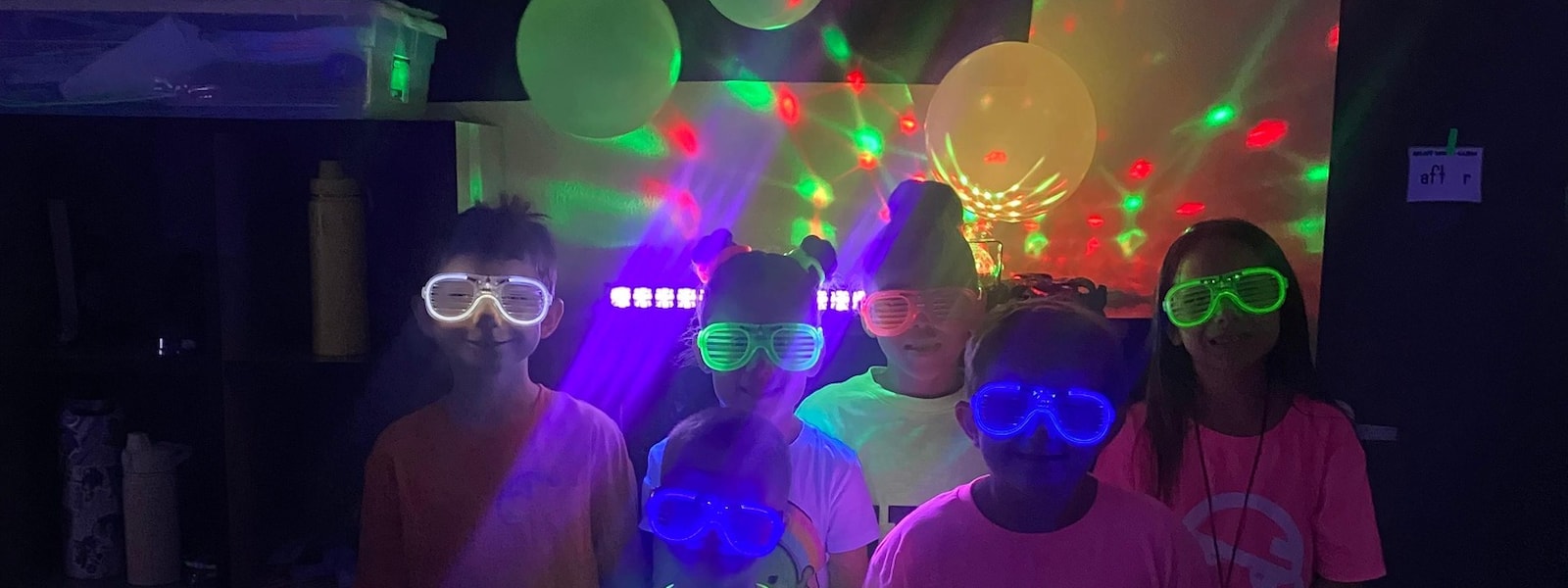 Students with neon glasses and neon balloons  