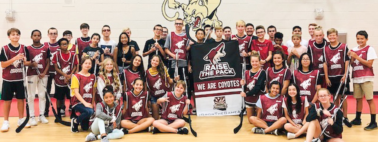 Students in Arizona Coyotes gear pose for a photography.