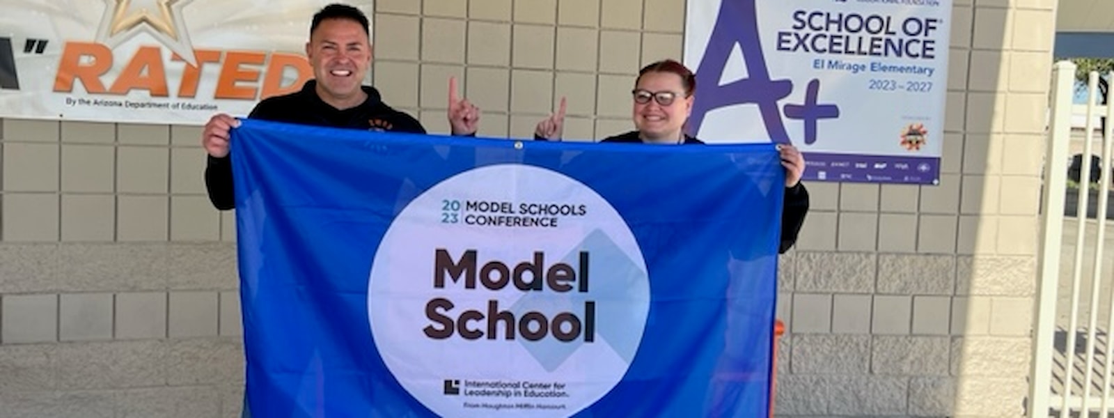 El Mirage administrators hold up the Model School banner.
