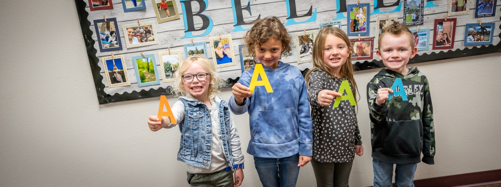 Students holding the letter "A"