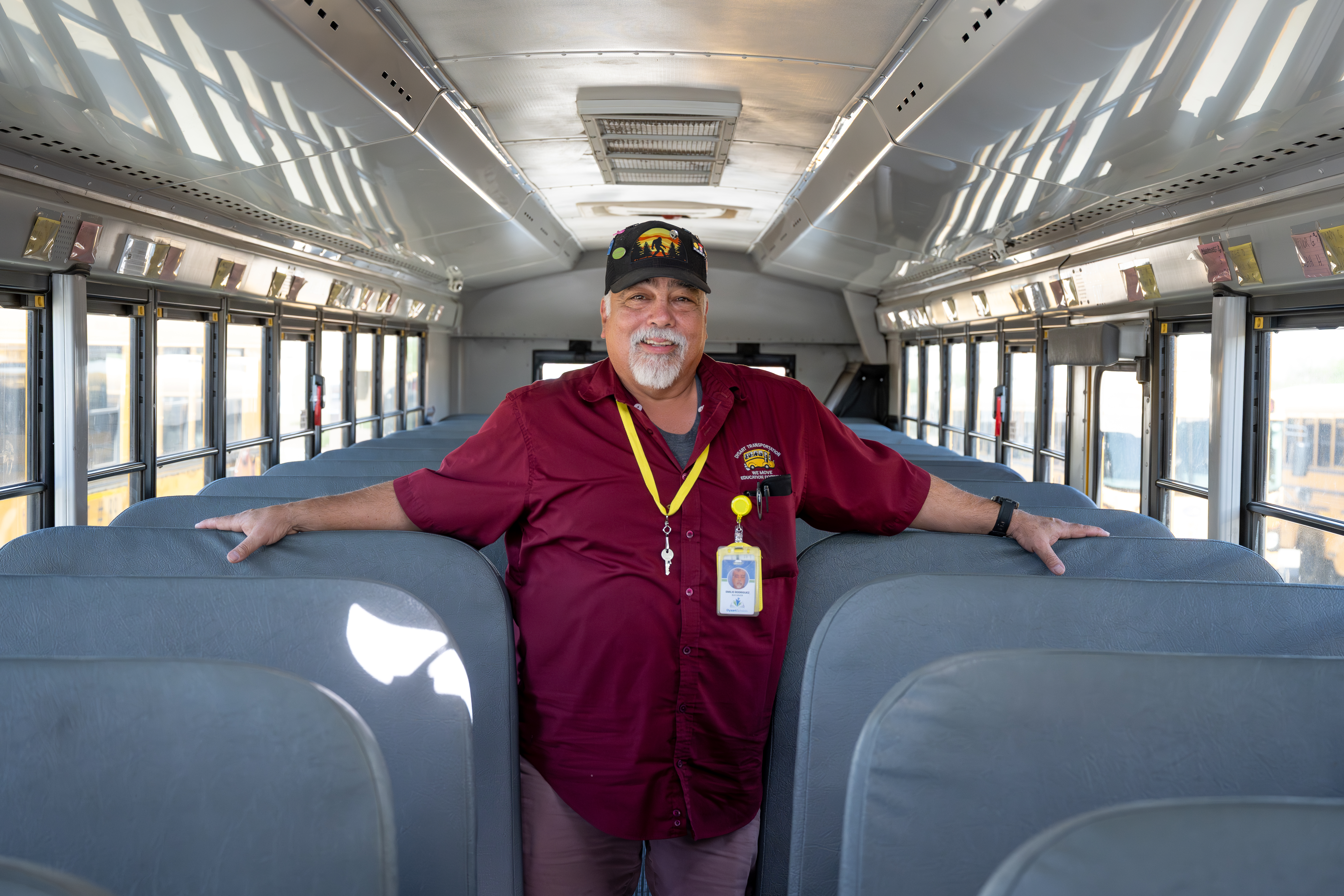 Photo of a school bus driver posing on a bus.